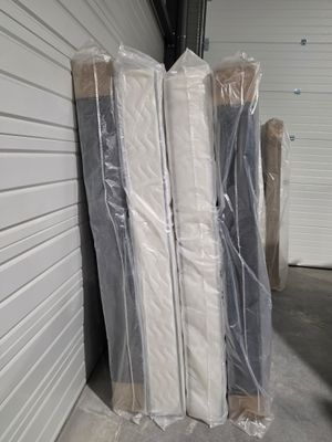 une pile de matelas emballés dans du plastique dans un débarras