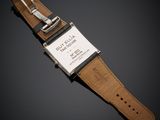 a close up of a watch on a black surface with a black background