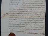 un vieux document muni d'un cachet de cire, posé sur une table
