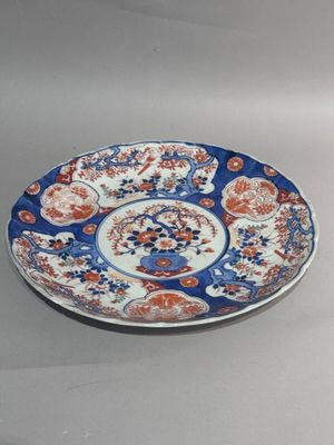 a blue and white plate with red flowers on it