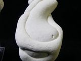 a white sculpture of a human head on a clear stand