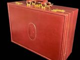 a red suitcase with gold handles on a black background