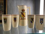 quatre tasses et un pichet posés sur une table en verre