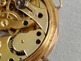 an image of a close up of a gold watch with a white background
