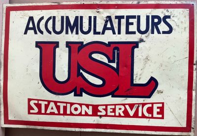 un panneau indiquant « USL Station Service » sur la façade d'un immeuble