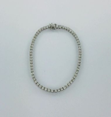 gros plan d'un bracelet en diamant sur une surface blanche