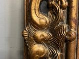a gold dragon on a mirror in the corner of a room