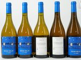 six bouteilles de vin sont alignées sur une surface blanche