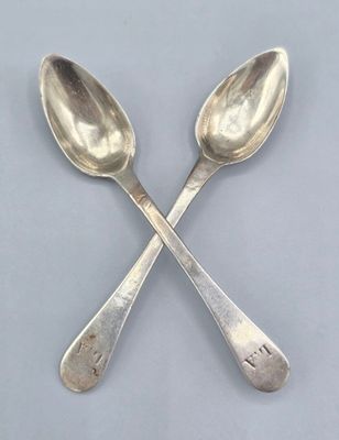 une paire de cuillères en argent posées l'une sur l'autre sur une table