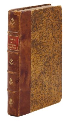 an old book with a brown cover sitting on top of a white surface