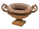 un grand vase en pierre muni d'une anse et posé sur un socle