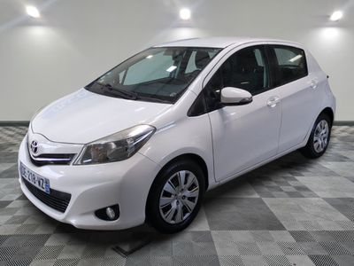 the white toyota yaris is parked on a checkered tile floor