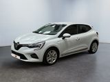 une voiture blanche garée dans une pièce blanche au sol noir