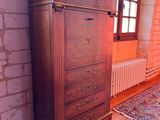 a wooden cabinet in a room with a rug on the floor
