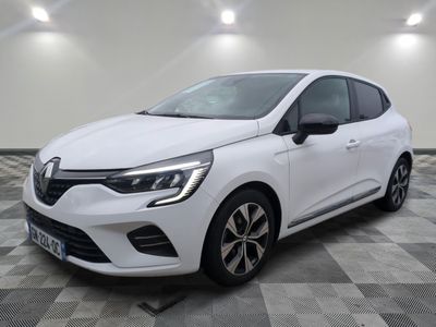 a white car is parked on a checkered floor in a garage