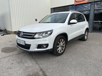 une Volkswagen Tiguan blanche garée devant un immeuble