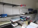 a room with a lot of books and papers on the shelves