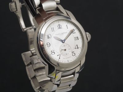 une montre en argent avec un cadran blanc sur fond noir
