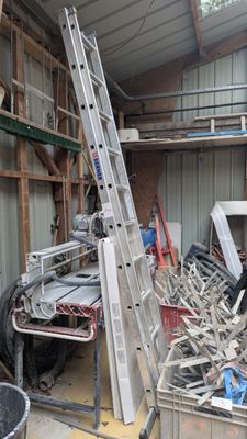 une photo d'un garage avec une échelle et un tas de bric-à-brac