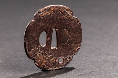 une petite pièce de bronze posée sur une table, dont l'ombre se projette sur le sol
