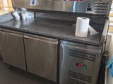 un comptoir en acier inoxydable dans un restaurant, sur lequel sont posées des tasses de café