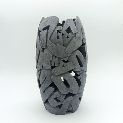 un vase noir qui est criblé de trous