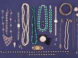 many necklaces and bracelets laid out on a blue surface