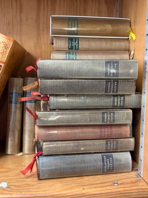 de nombreux livres empilés sur une étagère dans une bibliothèque