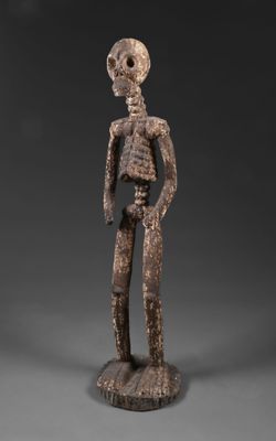 une figurine en bois représentant un homme avec un crâne sur la tête