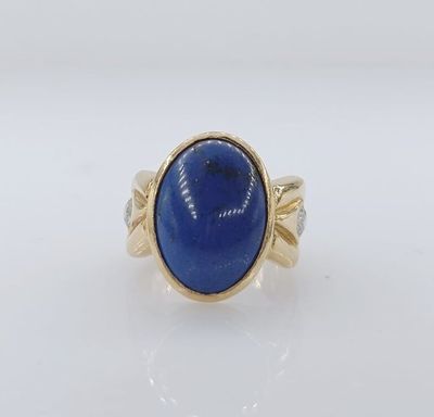 une bague en or avec une pierre bleue au centre
