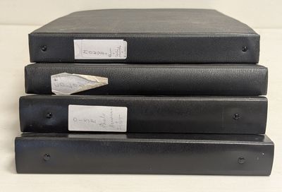 trois classeurs noirs empilés les uns sur les autres sur une table