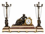a statue of a woman sitting on a table next to a clock