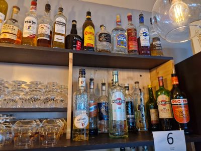 de nombreuses bouteilles et verres sur les étagères d'un bar