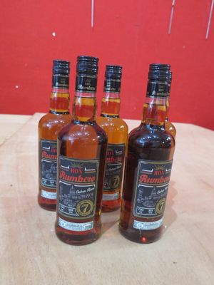 quatre bouteilles de whisky sont posées sur une table devant un mur rouge