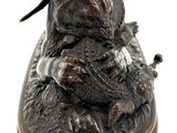 bronze statue of a dog and a cat on a wooden base