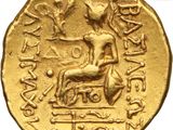 a close up of a gold coin with an image of a man sitting on a bench