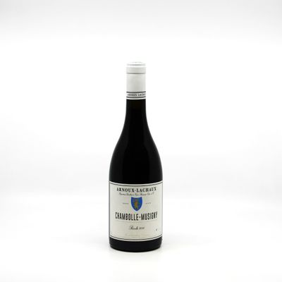 the bottle of wine is sitting on a white surface