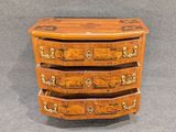 a small wooden chest of drawers with drawers on it
