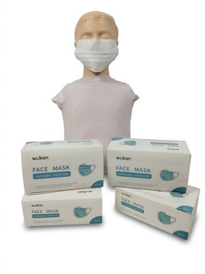 une personne portant un masque à côté de trois boîtes de masques jetables