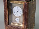 a small clock sitting inside of a box on a table