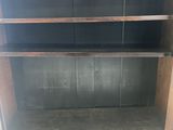 a wooden bookcase with two shelves and one door open