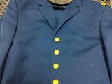 a blue jacket with yellow buttons and a hat on it