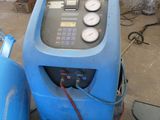 a blue air compressor sitting next to a blue tank