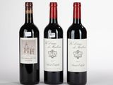 trois bouteilles de vin sont alignées sur une surface blanche