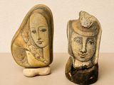 two stone sculptures of a woman and a man on a table