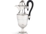 une cafetière ancienne en argent avec une poignée noire sur fond blanc