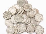 un tas de vieilles pièces d'argent sur fond blanc