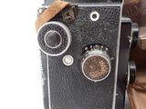 an old camera sitting on top of a piece of luggage