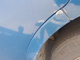 a close up of a car ' s front fender with a hole in the side of it