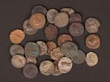 some old coins are scattered on a black surface with a small amount of them